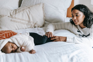 Black mother tenderly looking at her newborn baby, capturing the intimate bond and joy of early motherhood. The image reflects the beauty and challenges of postpartum life, symbolising maternal love and the beginning of a lifelong journey.